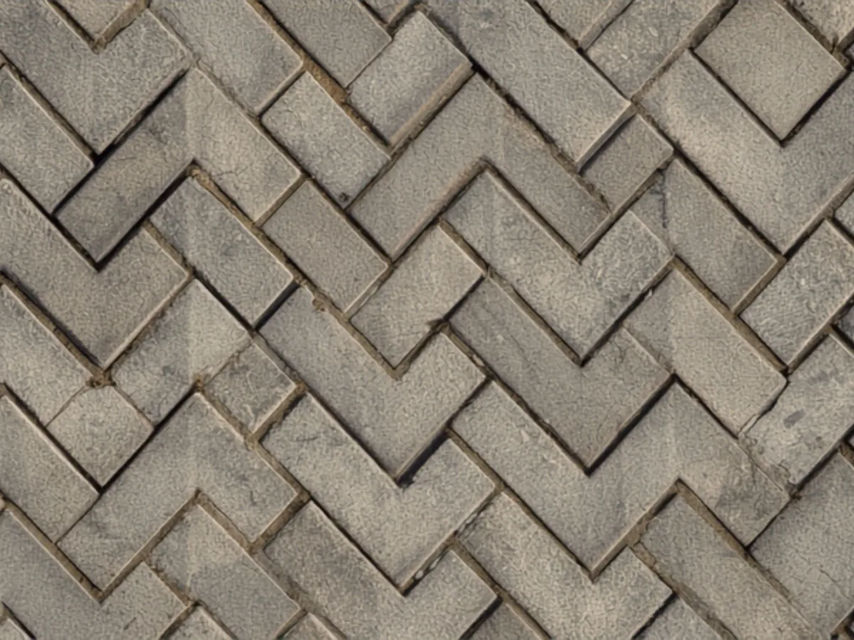 Close view of concrete pavers in a 45 degree herringbone with sand filled joints.